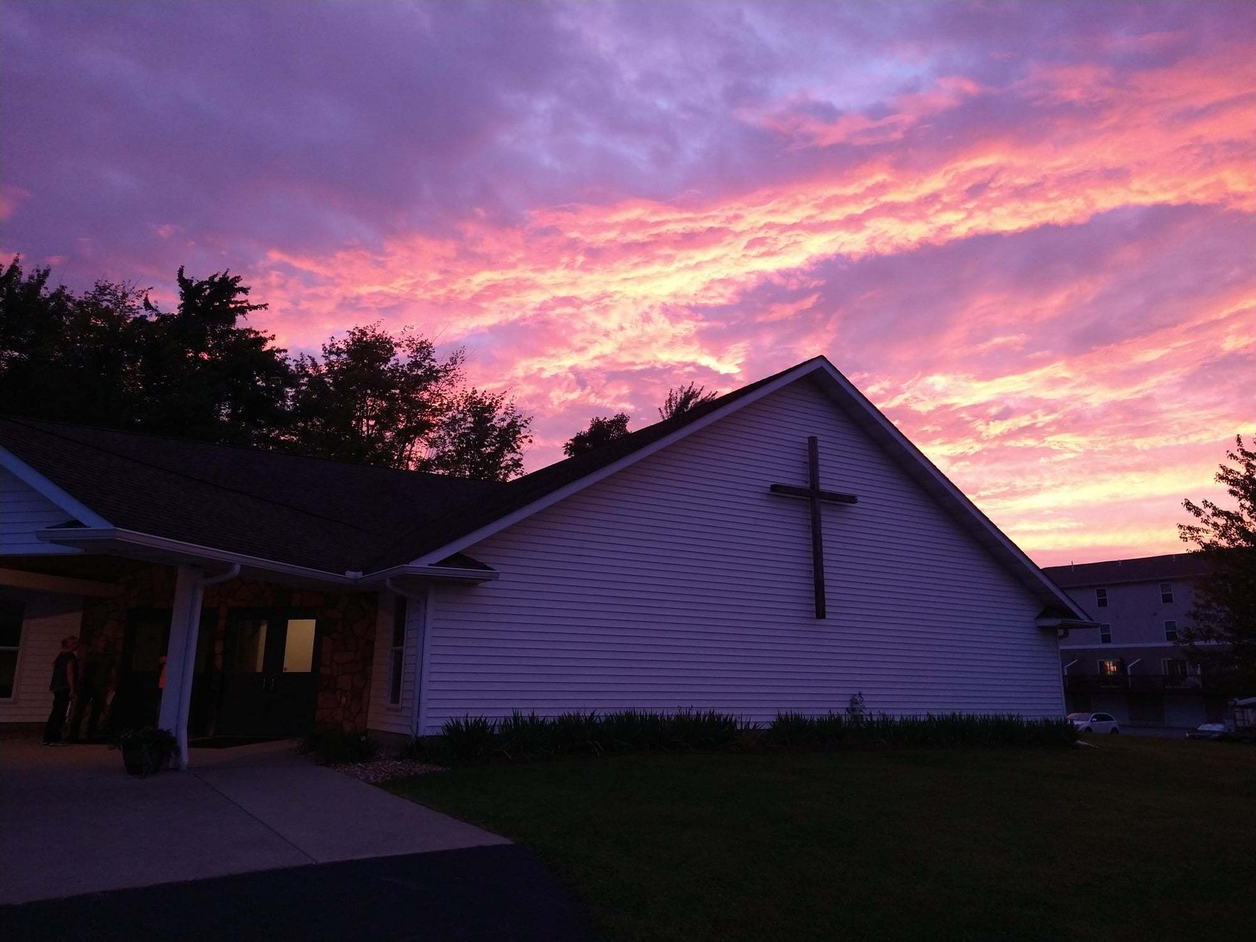 The Fairview Bible Church building at sunset, with the cross on its gable